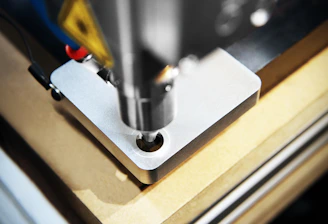 Close-up of a CNC milling machine precisely shaping a metal part in a bright workshop.