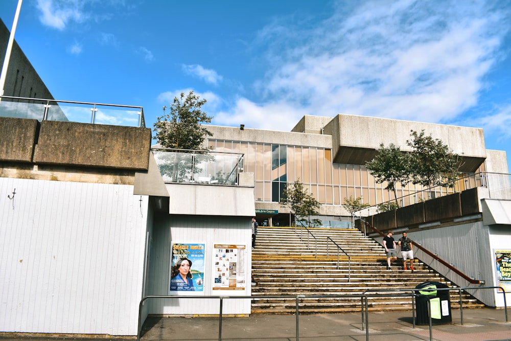 white concrete building with people sitting on bench