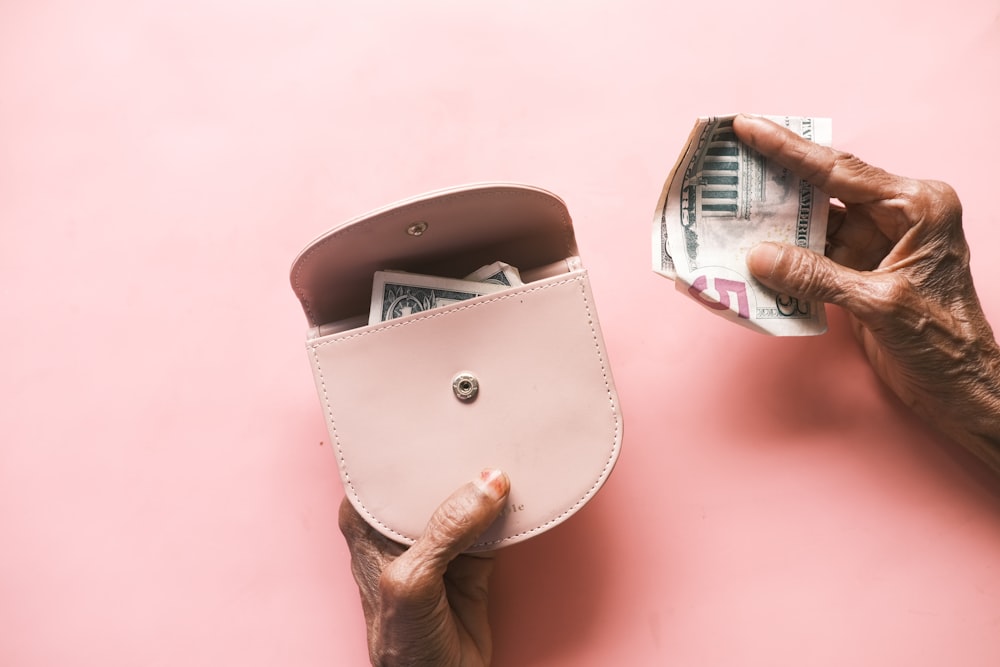 brown leather hand bag on pink table