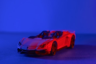 Close-up of a sleek red RC car motor gleaming under studio lights