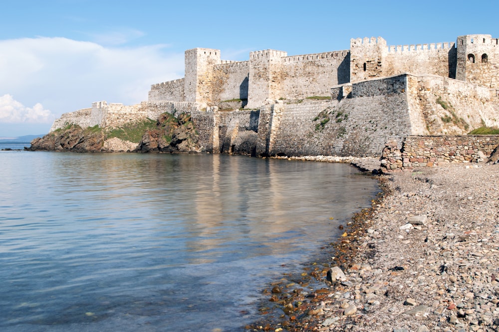 brown concrete castle on body of water during daytime