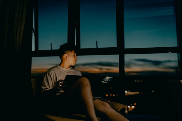 A calm evening scene with someone watching a series on a tablet in bed.