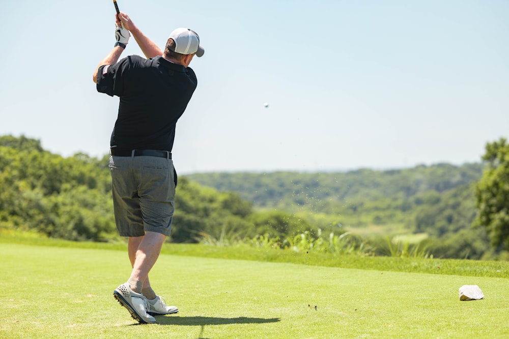 homme en chemise noire et short marron tenant un club de golf pendant la  journée photo – Photo Le golf Gratuite sur Unsplash