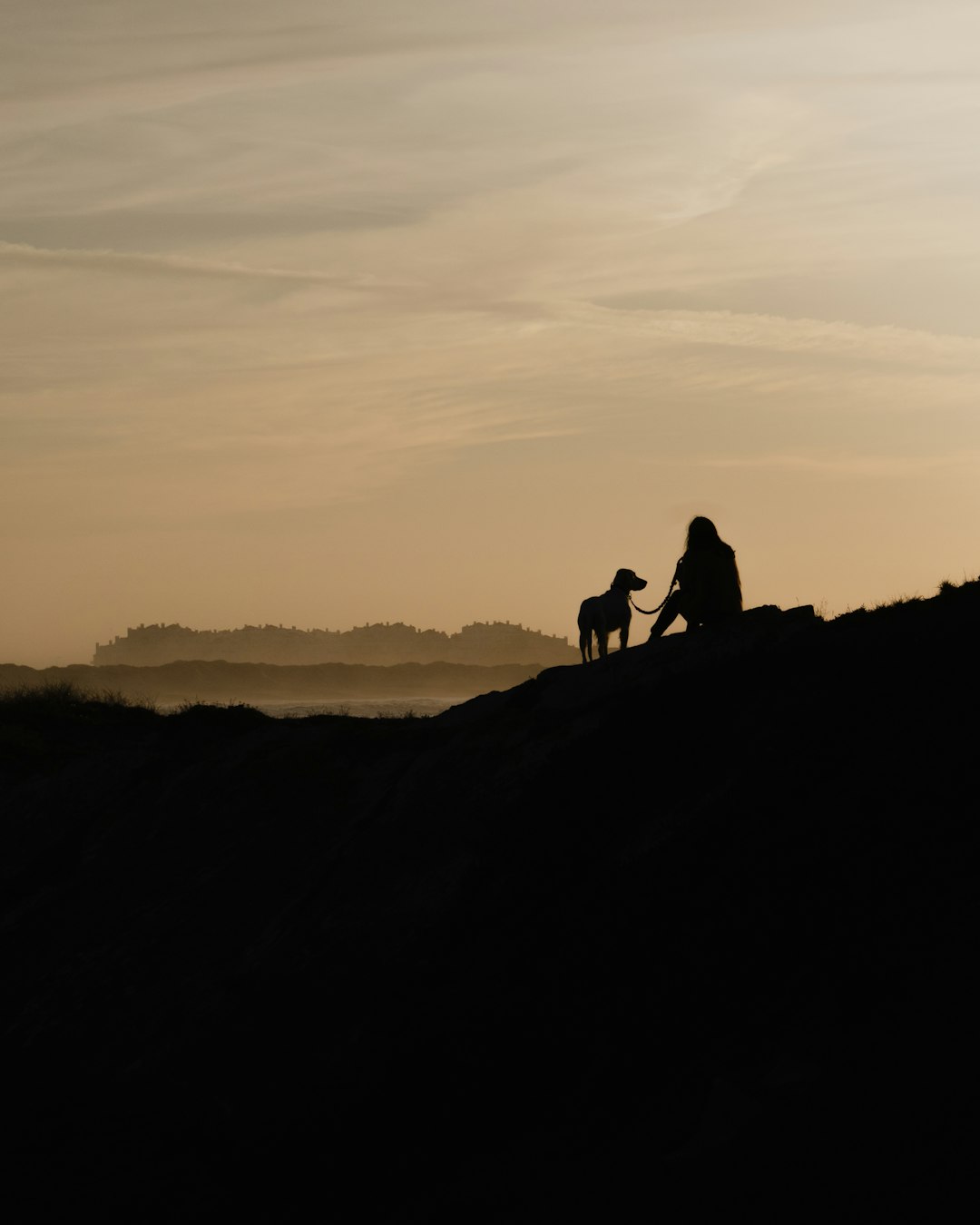 silhouette of 2 person standing on mountain during sunset