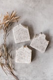 Men’s scrub soap bar resting on natural stones with a rugged background