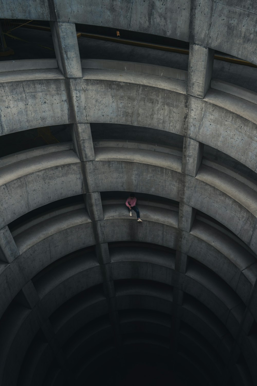 person in red jacket walking on brown tunnel