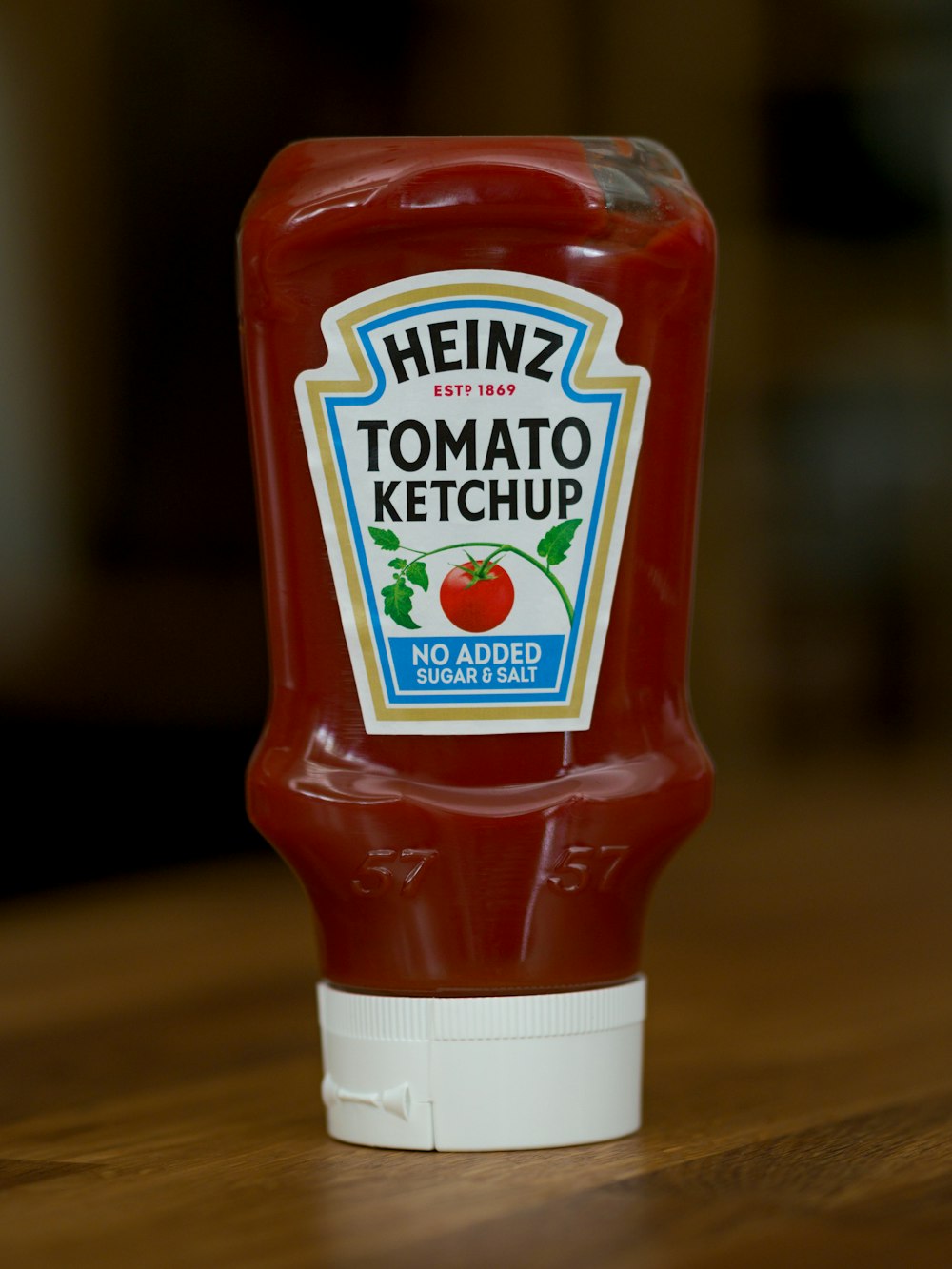 Botella de salsa de tomate Heinz sobre mesa de madera marrón