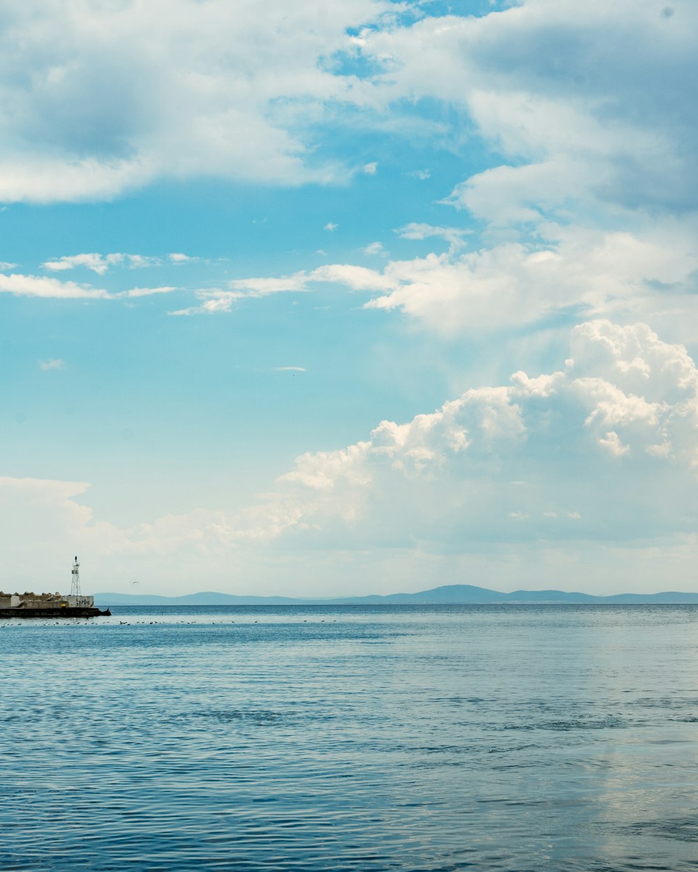 barco blanco en el mar bajo el cielo azul y las nubes blancas durante el día