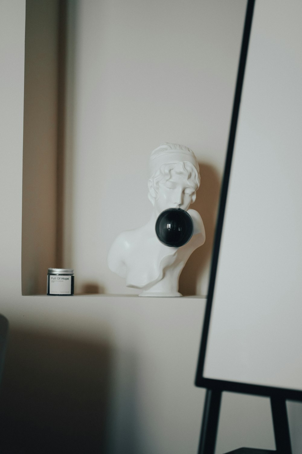 white ceramic figurine on white wooden shelf