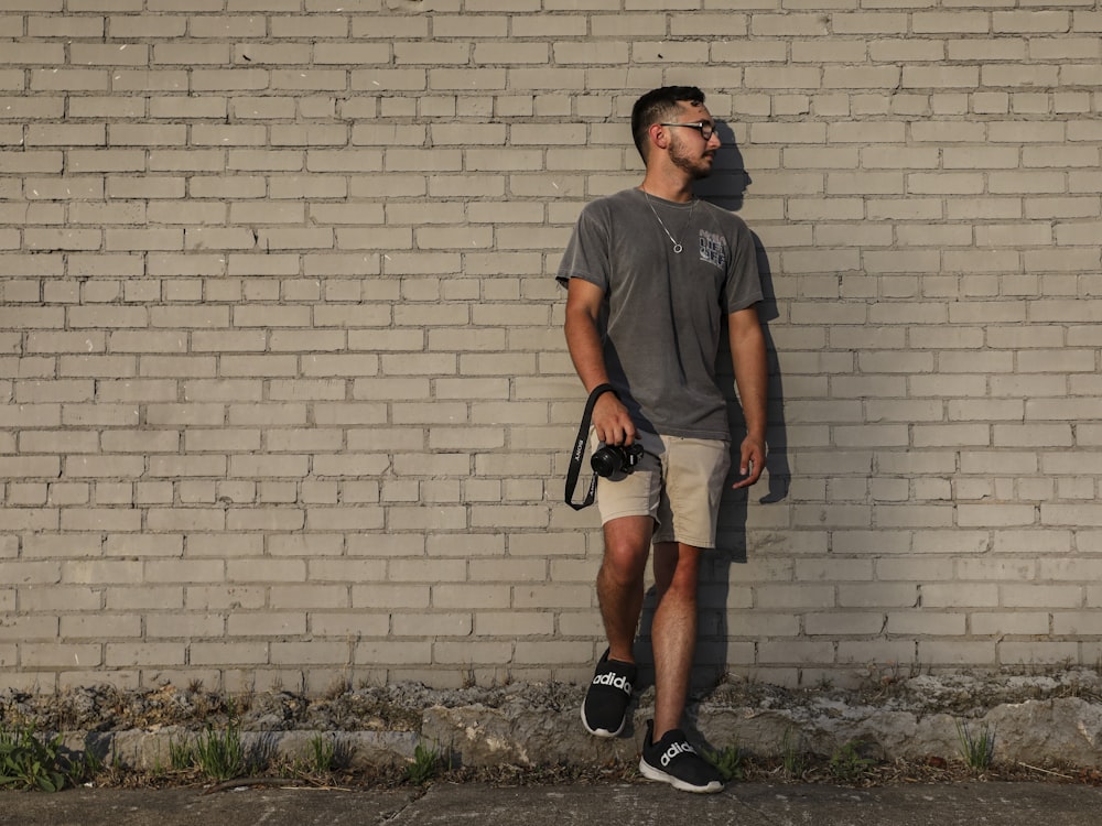 man in black crew neck t-shirt and black shorts standing on green grass field