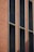 A close-up view of a building facade featuring vertical panels. The structure has a distinct geometric design with alternating sections of textured reddish-brown and dark gray materials. Narrow vertical windows are uniformly spaced along the facade.