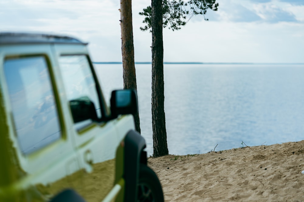 white suv parked near body of water during daytime