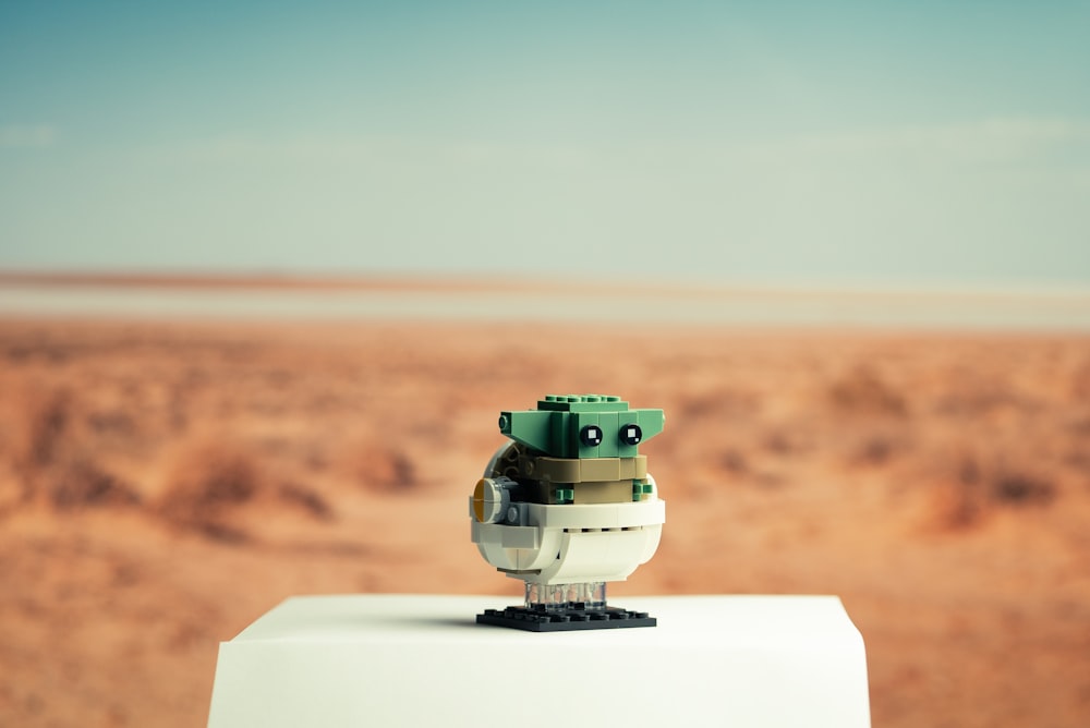 green and white toy robot on white table