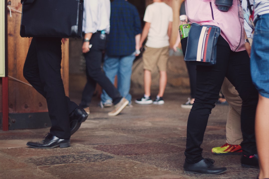 man in black pants and white shirt walking on street