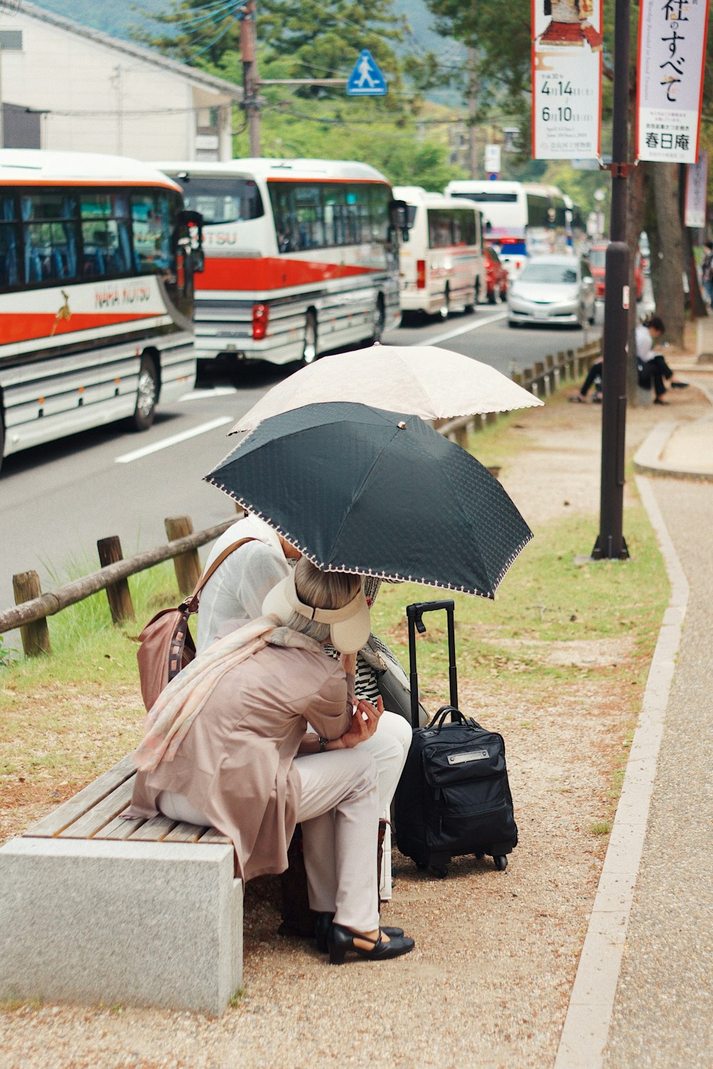 woman in brown coat holding umbrella walking on sidewalk during daytime