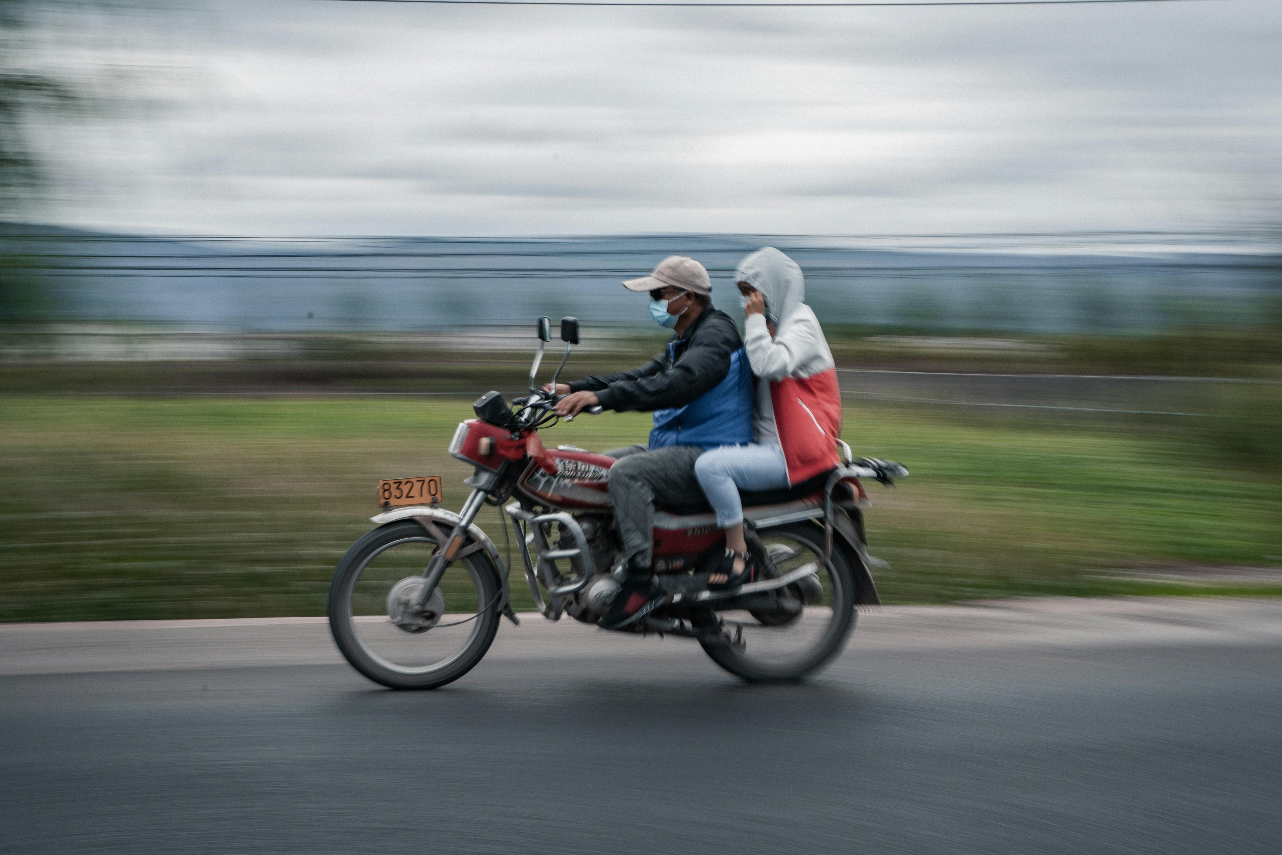man and woman riding motorcycle on road during daytime