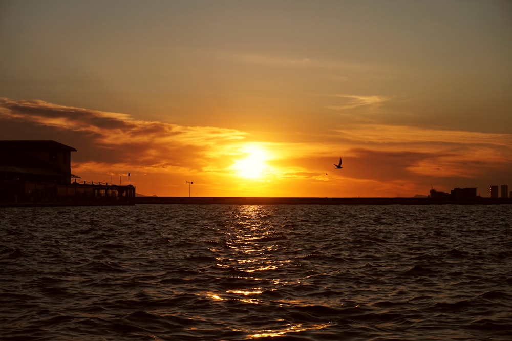 silhouette of people on dock during sunset