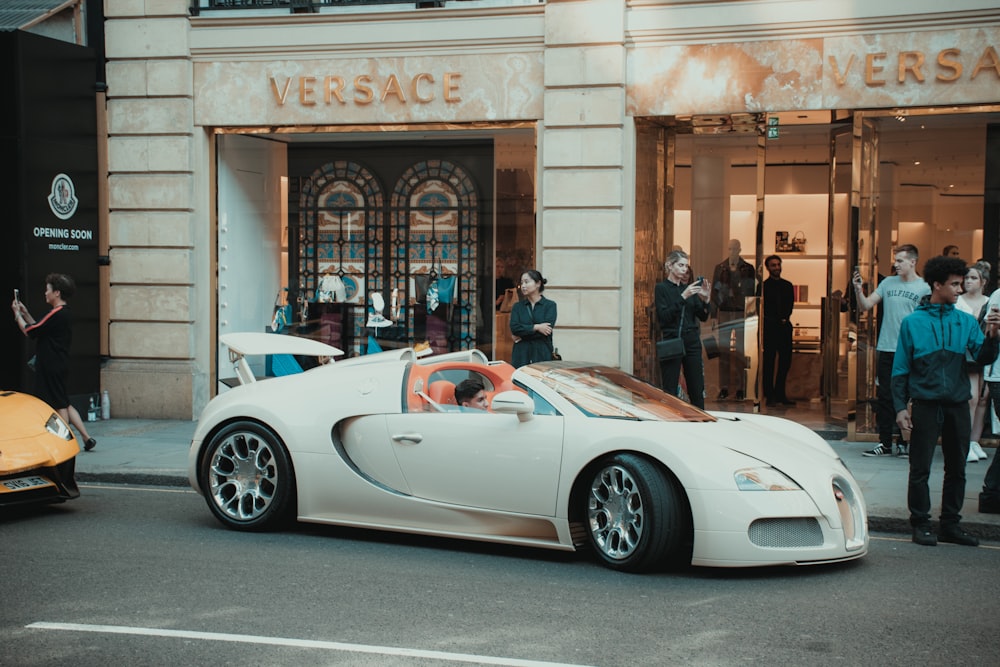 white porsche 911 parked in front of building