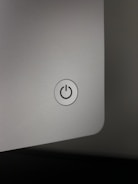 Artistic shot of a glossy silver switch reflecting soft light on a clean background.