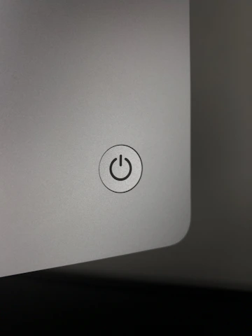 Close-up of metallic gold call-to-action button glowing against matte black background.