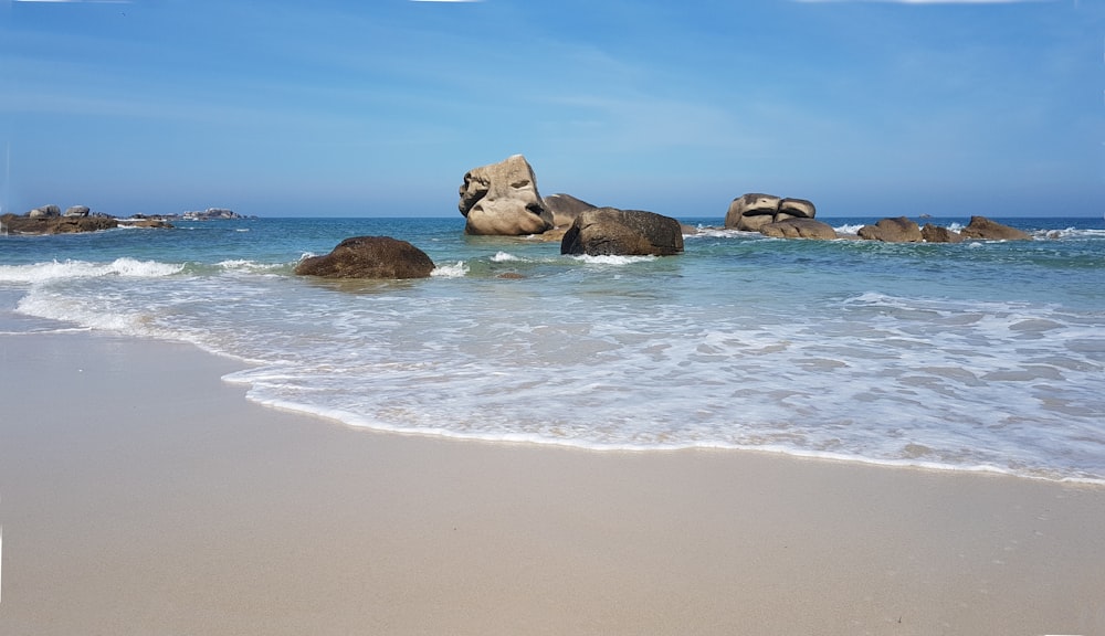 Formazione rocciosa marrone sulla riva del mare durante il giorno