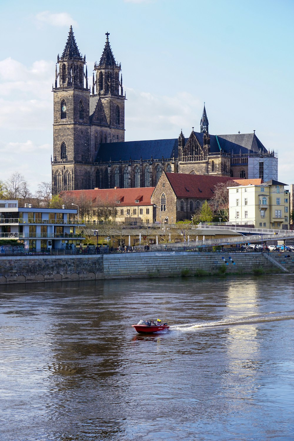 red and white boat on water near brown concrete building during daytime