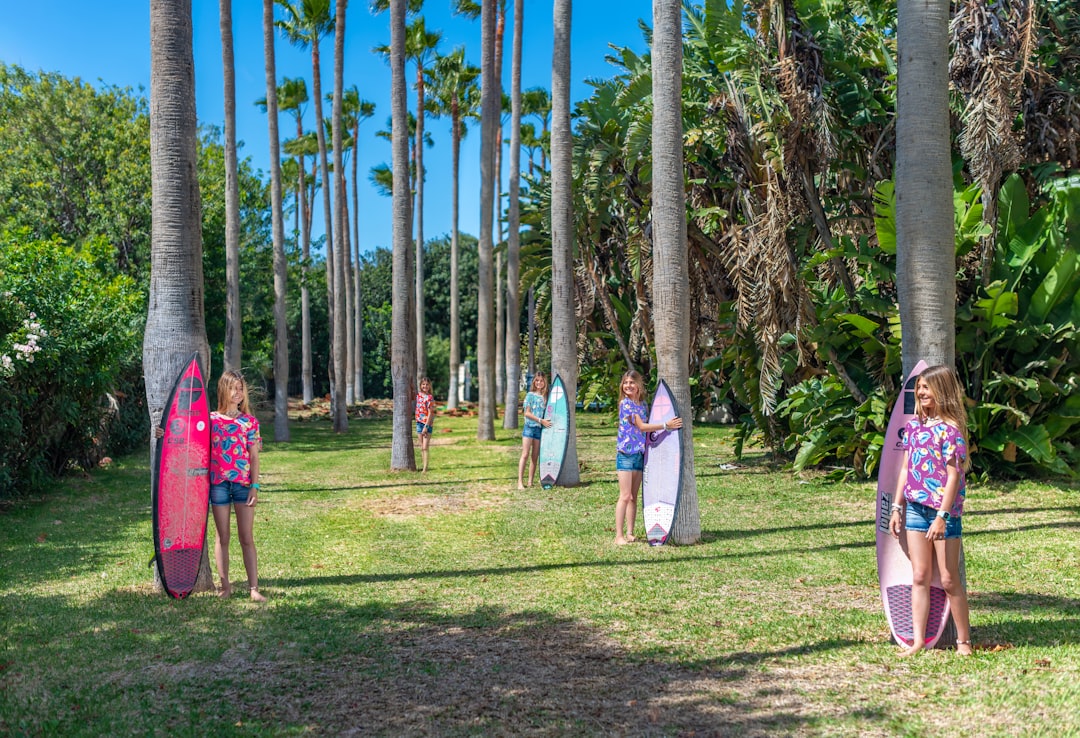 people standing on green grass field surrounded by green trees during daytime