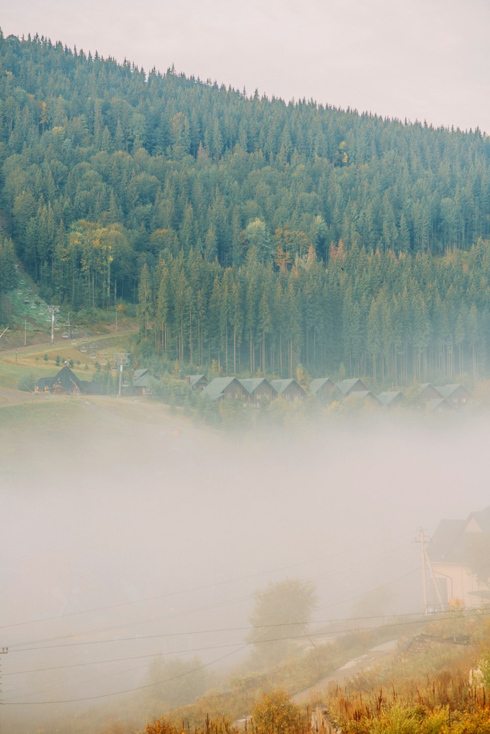 a foggy landscape with houses in the distance