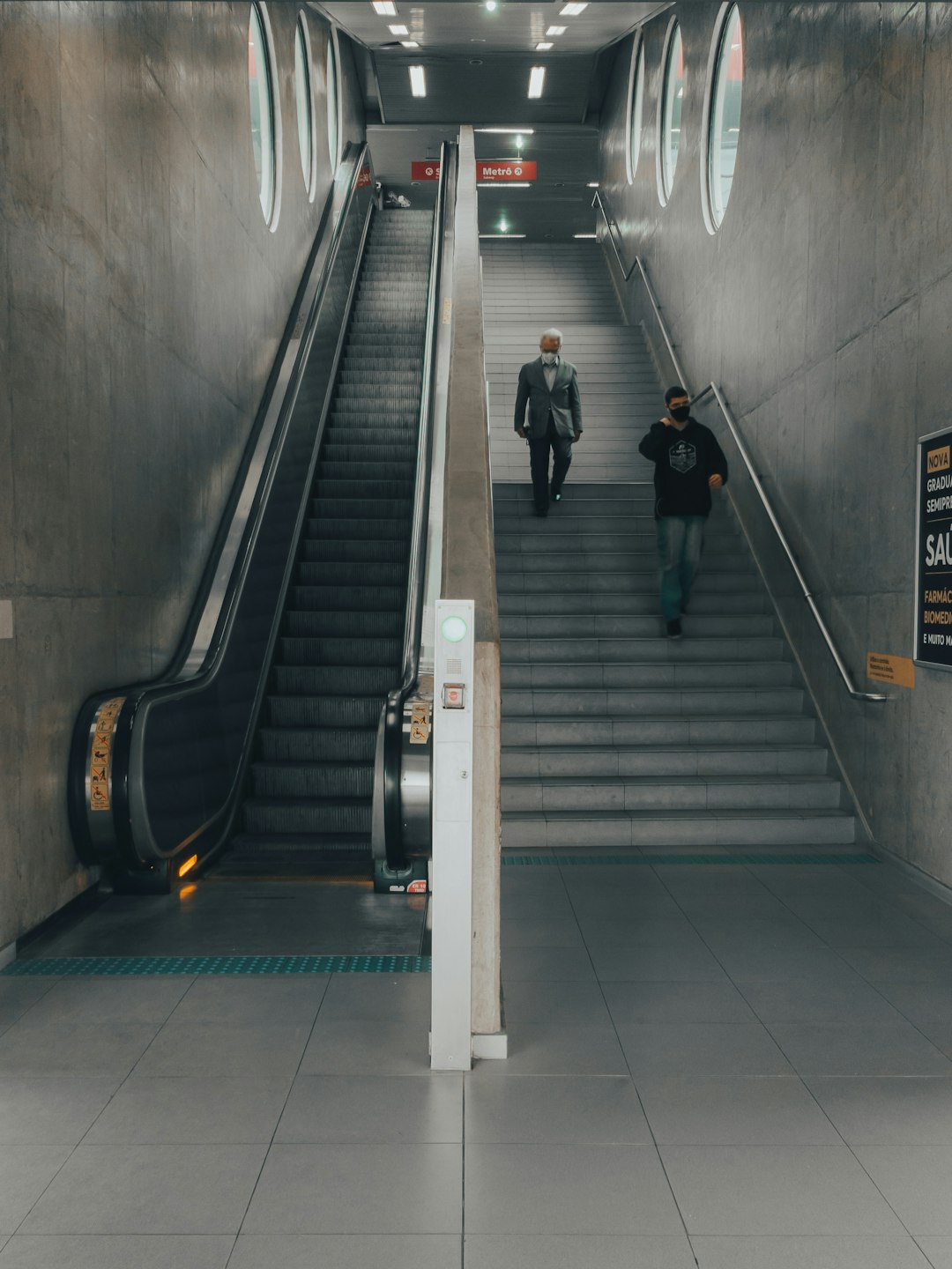 people walking on gray concrete hallway