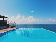Infinity pool overlooking the Red Sea with palm trees and clear blue skies.
