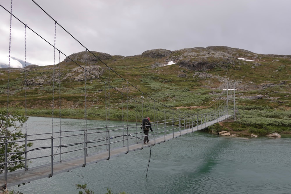 people walking on bridge over river during daytime