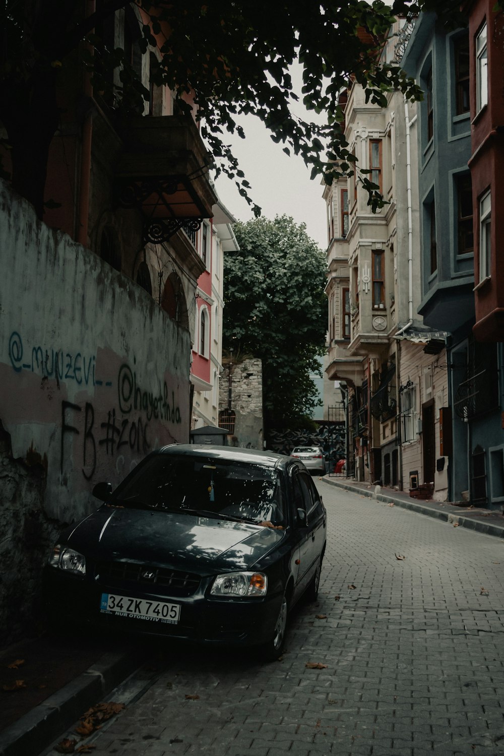 Auto nera parcheggiata accanto all'edificio in cemento bianco durante il giorno