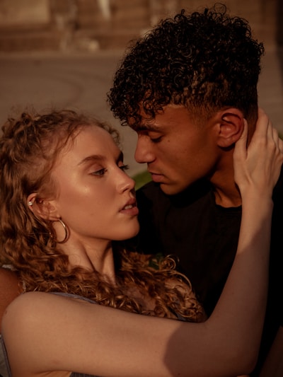 A couple embracing tenderly with soft golden light highlighting their closeness.