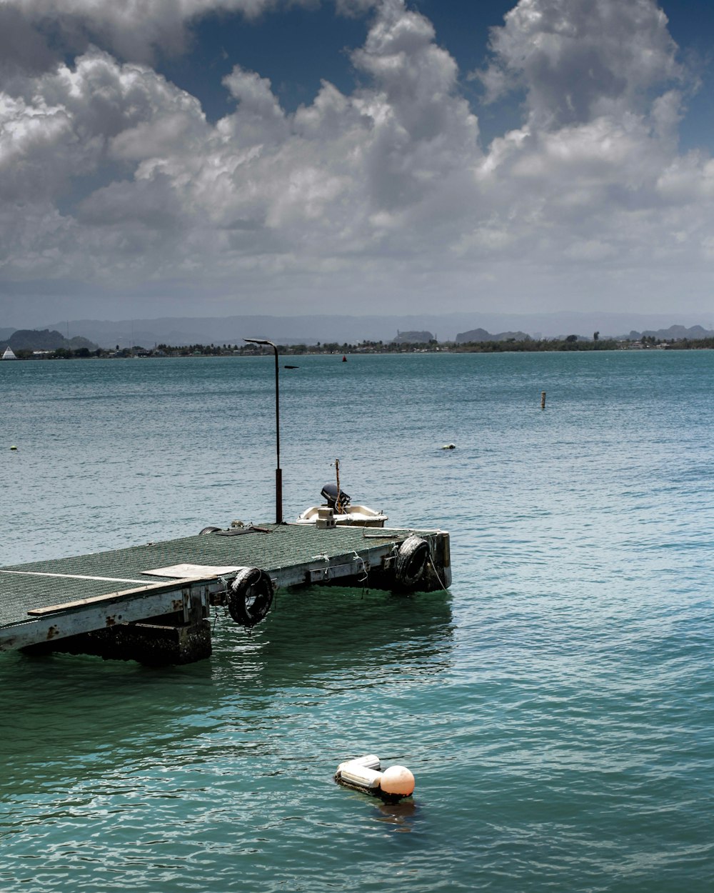 black and white boat on sea under white clouds during daytime