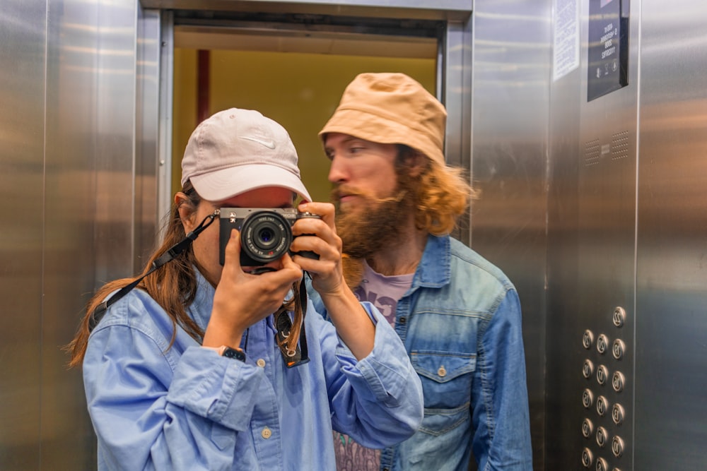 woman in blue denim jacket holding black camera