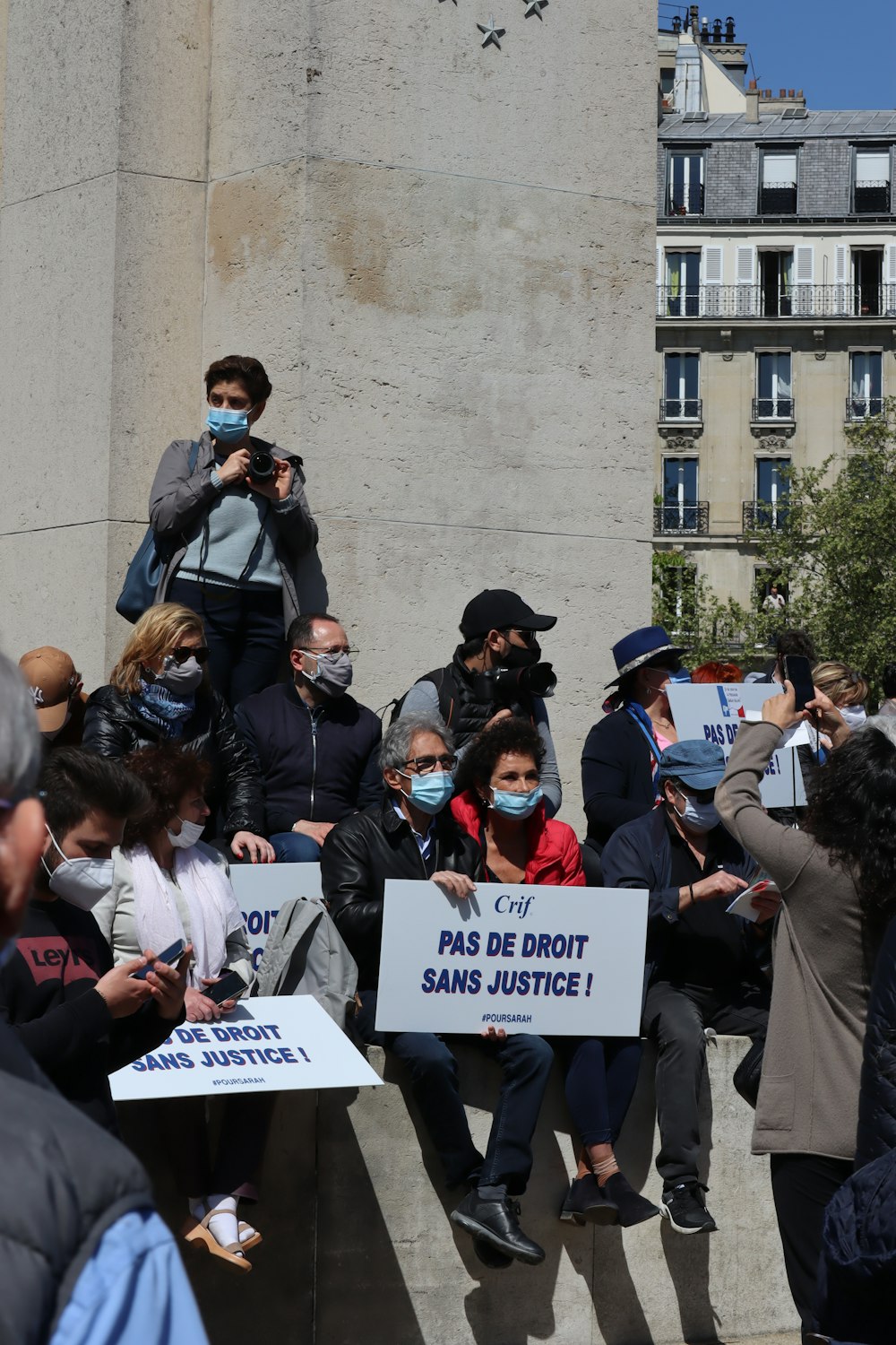 people standing and holding white printer paper during daytime