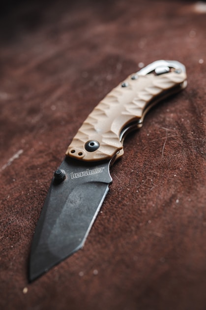 Hunting knife with wood handle on outdoor surface