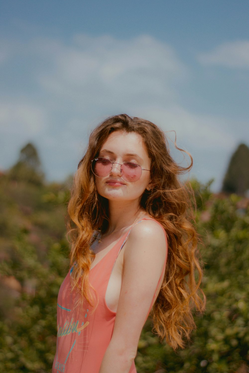 woman in orange tank top wearing eyeglasses