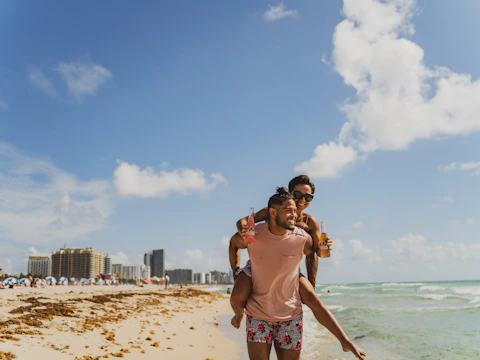 black couple playing on beach during daytime