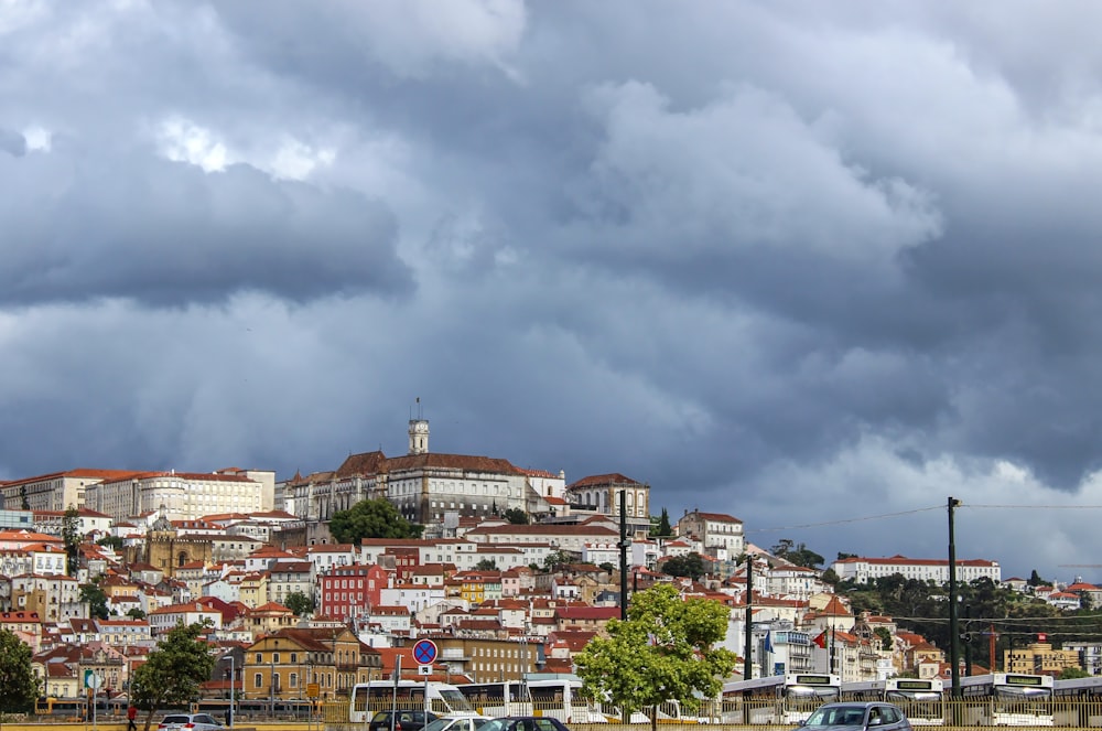 city with high rise buildings under white clouds during daytime