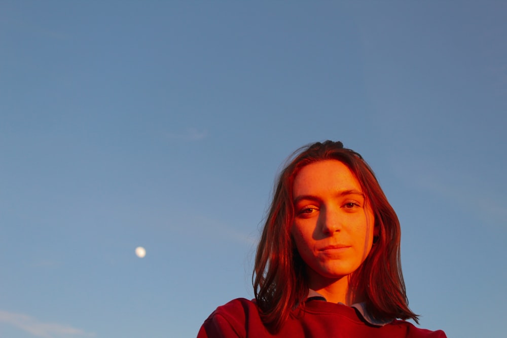 woman in red hoodie under blue sky during daytime