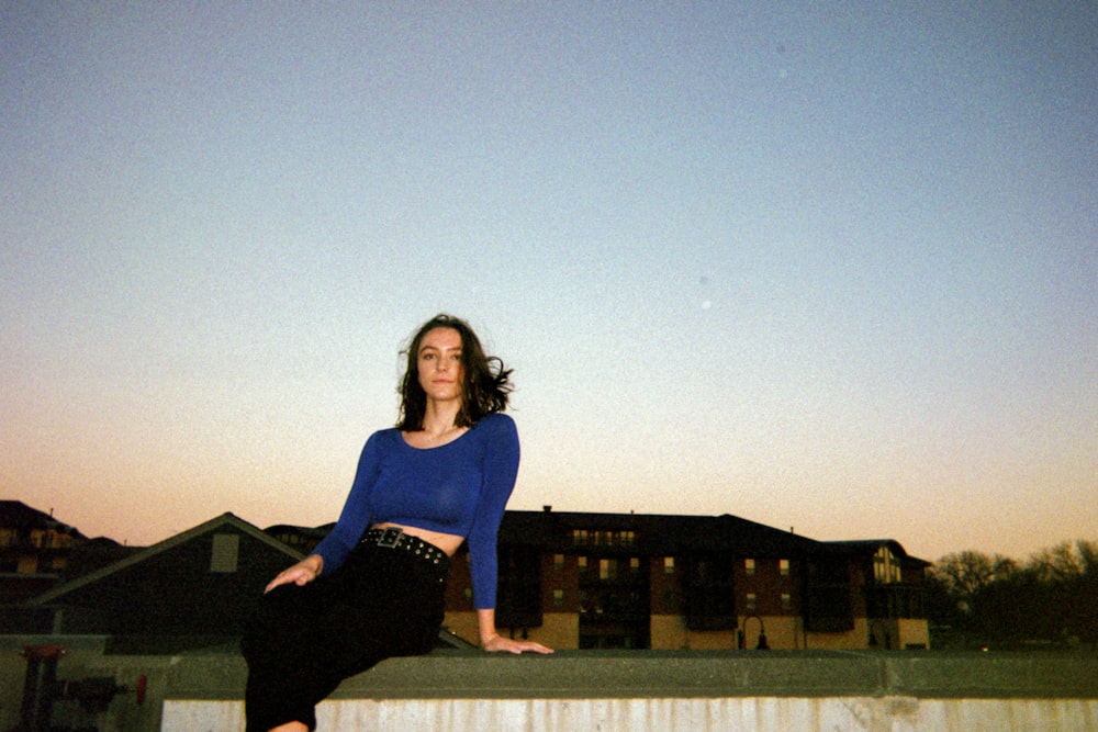 woman in black long sleeve dress standing on gray concrete floor during daytime