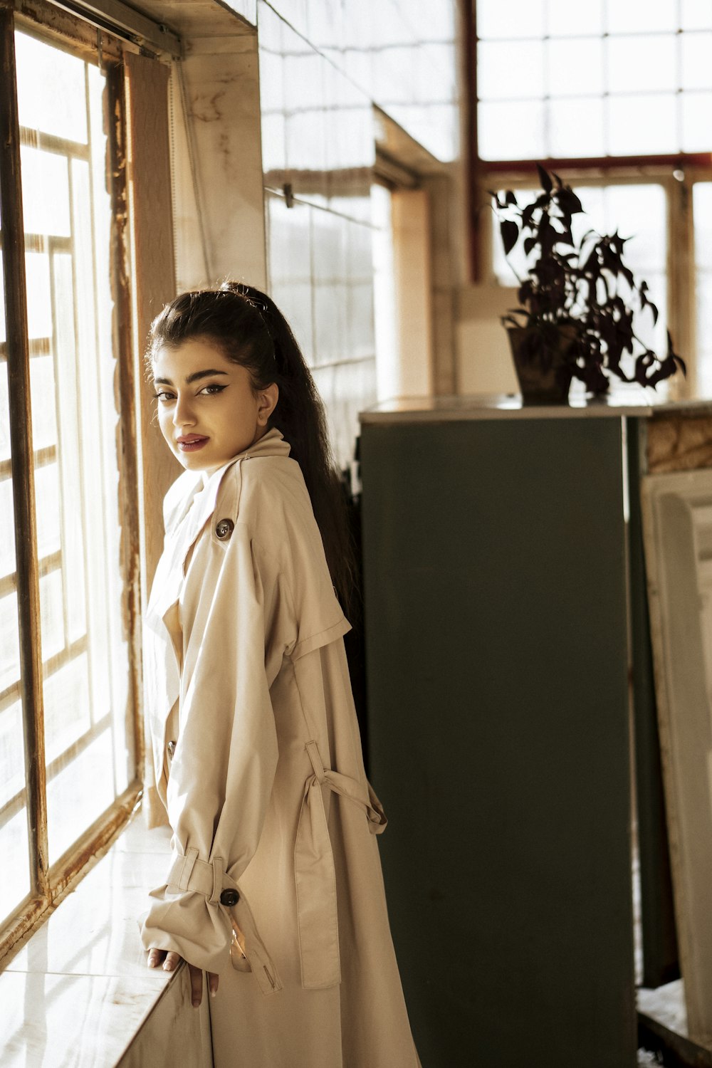 girl in white coat standing beside black refrigerator