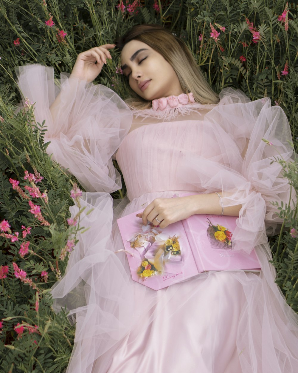 woman in white dress lying on green grass field