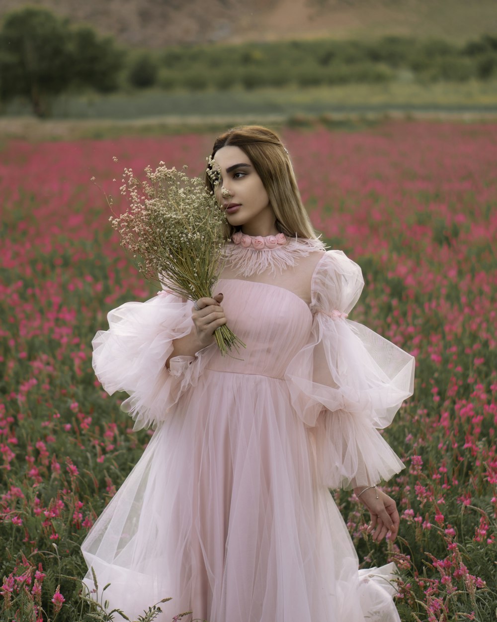 woman in pink dress holding bouquet of flowers