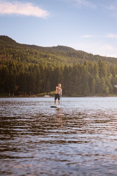 woman in black dress standing on river during daytime