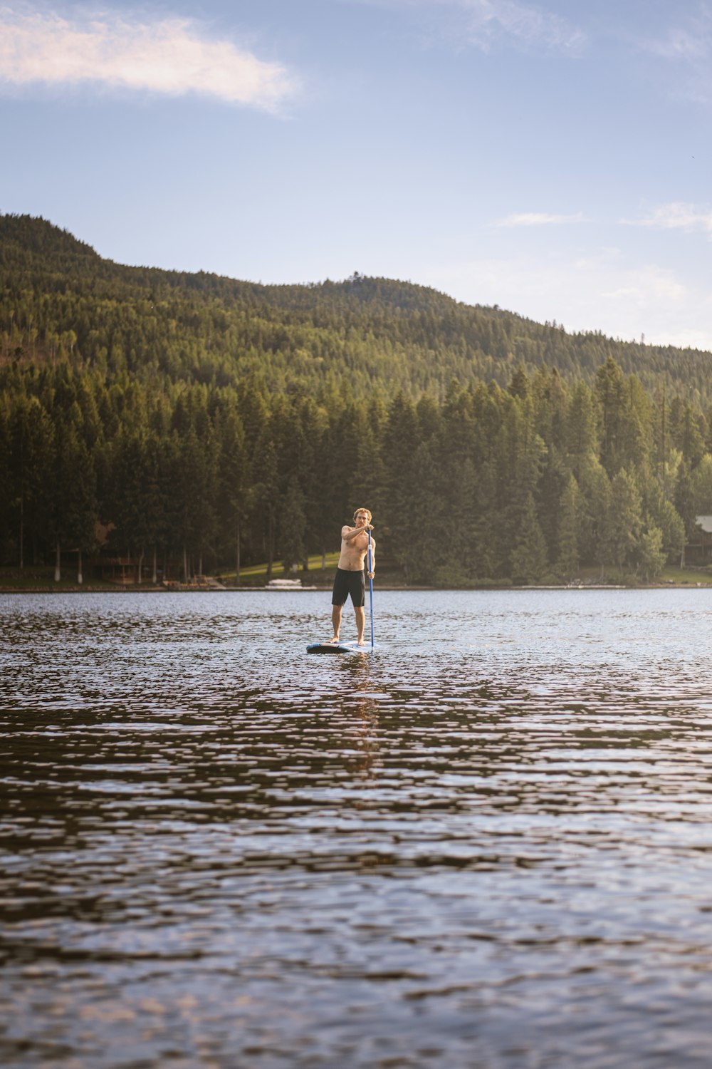 woman in black dress standing on river during daytime