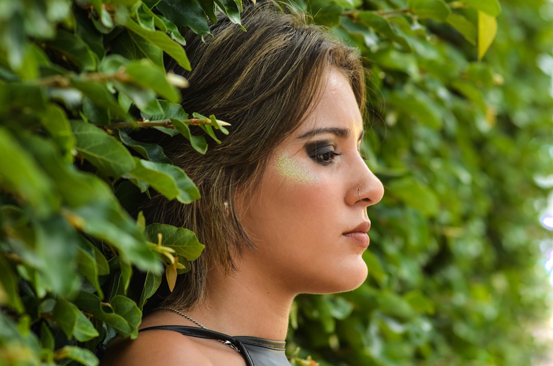 woman in black tank top standing beside green plant during daytime