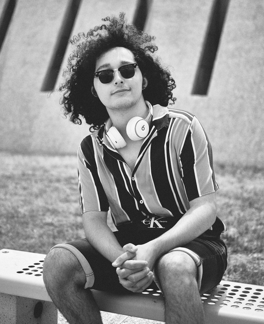 grayscale photo of woman in white and black stripe polo shirt and black sunglasses