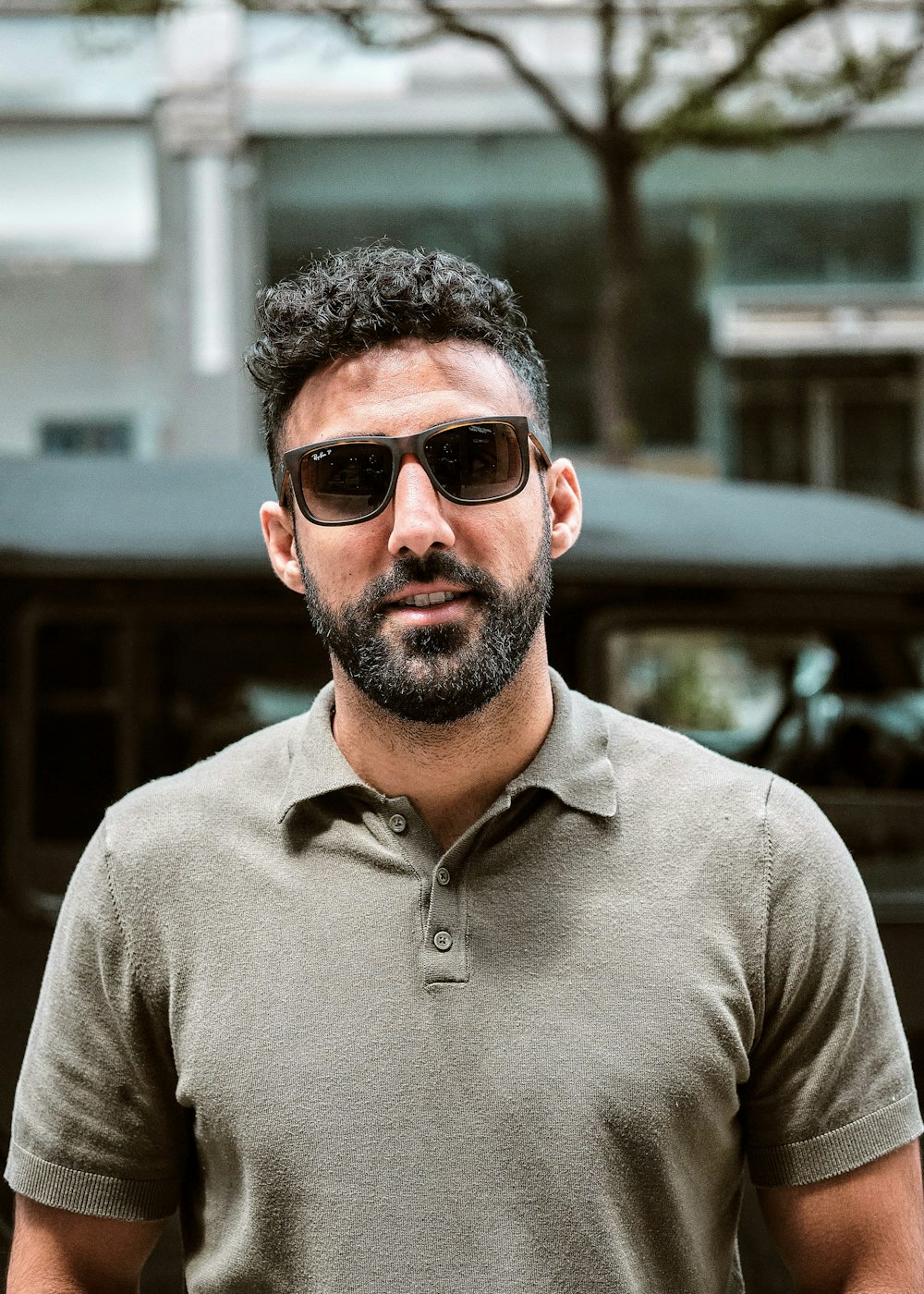 man in gray polo shirt wearing black sunglasses